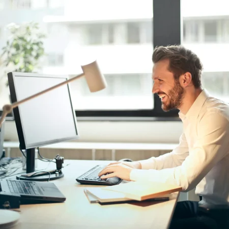 Profissional analisando relatórios financeiros em um computador com gráficos de contabilidade digital.