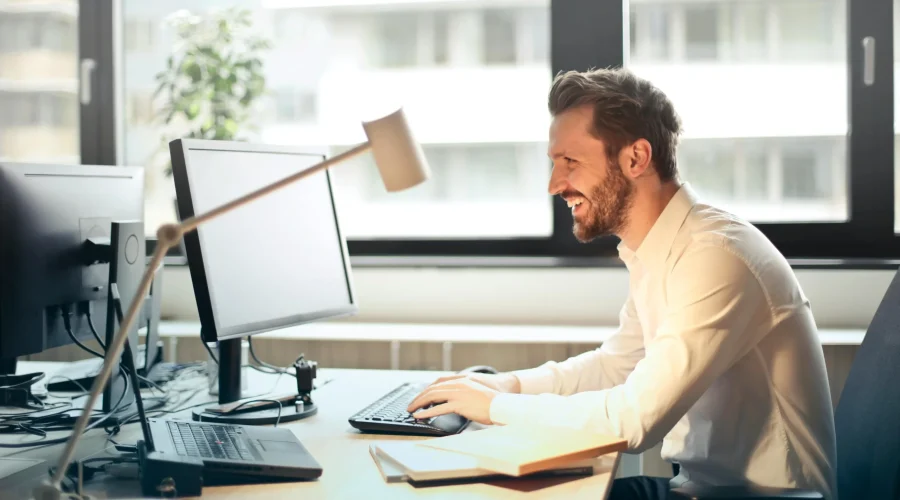 Profissional analisando relatórios financeiros em um computador com gráficos de contabilidade digital.